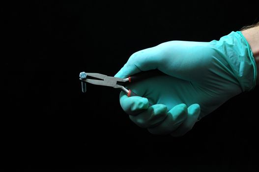 Pliers and a Hand on a Black Background