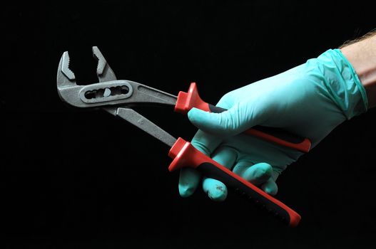 Pliers and a Hand on a Black Background