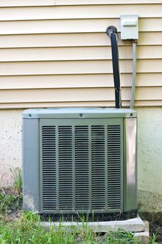 A residential central air conditioning unit sitting outside a home.