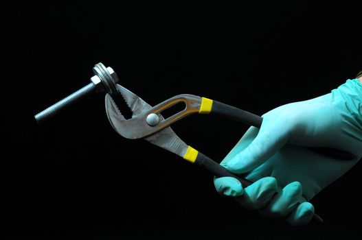 Pliers and a Hand on a Black Background