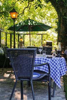 Outdoor cafe in sunlight, under the big old tree.