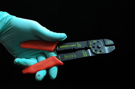 Pliers and a Hand on a Black Background