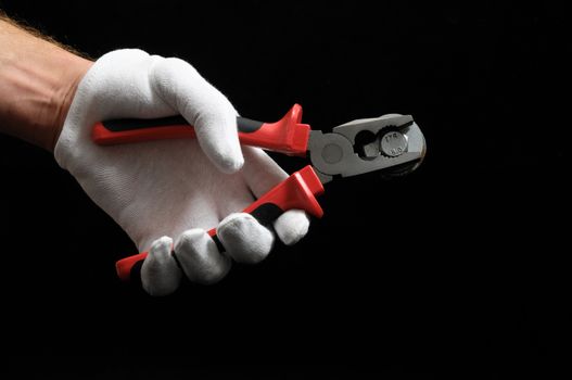 Pliers and a Hand on a Black Background