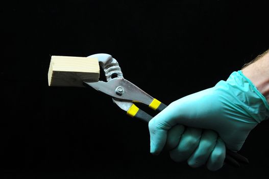 Pliers and a Hand on a Black Background