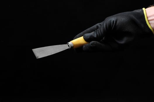 One Spatula and a Hand on a Black Background