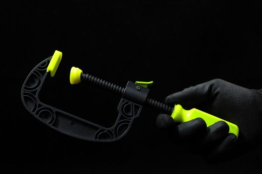 Pliers and a Hand on a Black Background