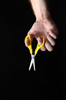 Scissors and a Hand on a Black Background