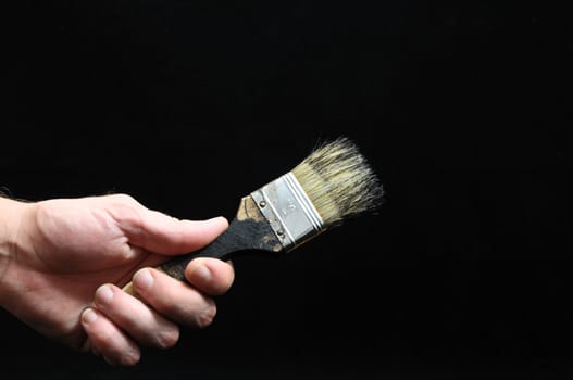 Brush  and a Hand on a Black Background