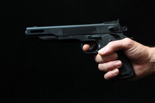 Gun and a Hand on a Black Background