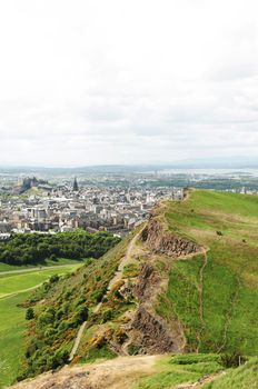 Arthur's Seat is the main peak of the group of hills which form most of Holyrood Park. It is situated in the centre of the city of Edinburgh, about a mile to the east of Edinburgh Castle. The hill rises above the city to a height of 250.5 m (822 ft), provides excellent panoramic views of the city, is relatively easy to climb, and is popular for hillwalking.