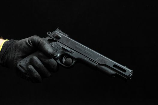 Gun and a Hand on a Black Background