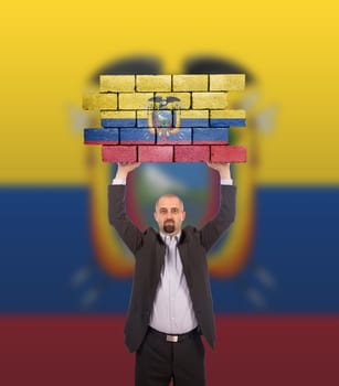 Businessman holding a large piece of a brick wall, flag of Ecuador, isolated on national flag