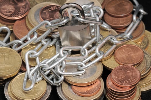 Secure Savings - a Lock and Some Coins on a Black Background