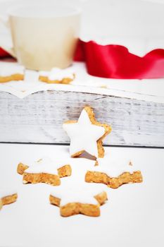 cinnamon stars for christmas in front of a white wooden tray with a cup and a red ribbon