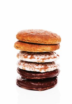 stack of different lebkuchen gingerbread cookies with chocolate and other icing on white background