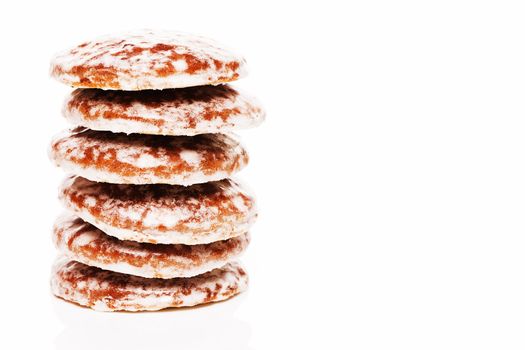 stack of traditional christmas lebkuchen gingerbread cookies with sugar icing on white background