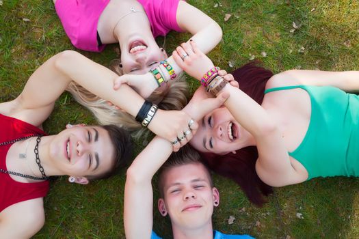 Four teenagers are having fun in the grass