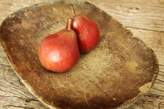 two red pears on wooden table close up 