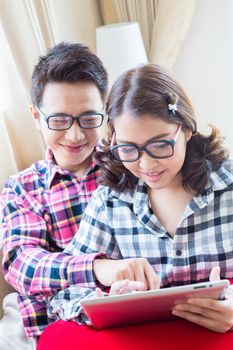 Couples with a tablet computer in living room (Selective Focus at Woman)