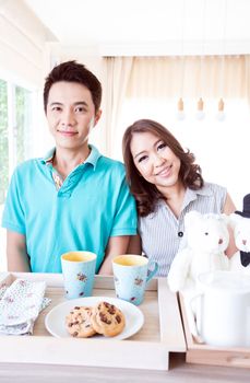 Young happy couples in domestic kitchen with breakfast