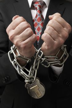 Close up of businessmans hands tied in heavy chains with padlock
