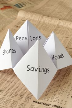 origami fortune teller on financial paper showing share prices