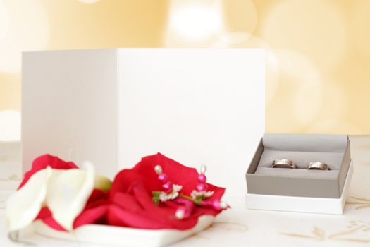 wedding announcement with rings and space for text, focus wedding announcement, blurred rings, focus to white paper with space for text