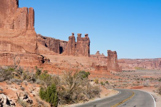 This image shows the drive into Arches where huge rock formations seem to have been thrust upward from the ground.