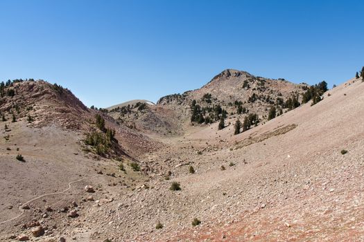 This is some of the terrain on Mount Lassen. There is a patch of snow in the background. Although some trees are growing this is still a stark area, but it is beautiful in it's own way.