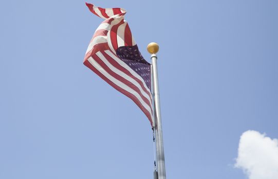 American flag waving with blue sky in the background