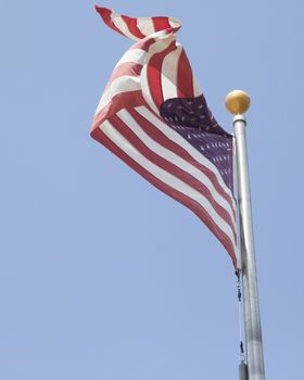 American flag waving with blue sky in the background