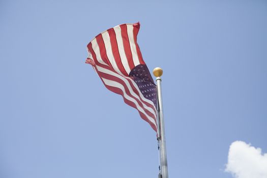 American flag waving with blue sky in the background