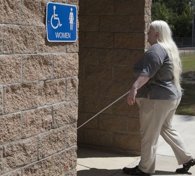 Blind waman walking into the women's restroom