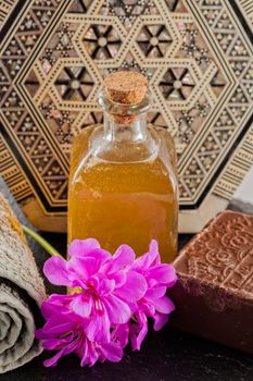 Brown soap, candle and towel over wooden background