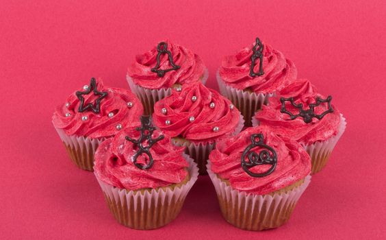 Group of Christmas cupcakes on red background