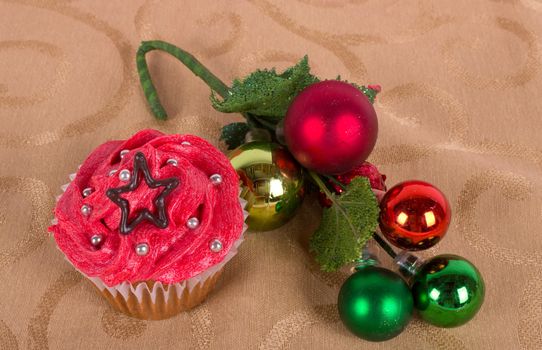 Christmas cupcake with tree ornament on gold background