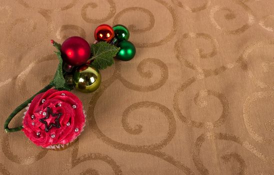 Christmas cupcake with tree ornament on gold background