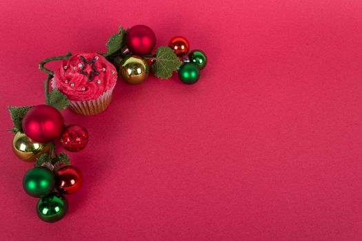 Christmas cupcake and tree ornaments on red background