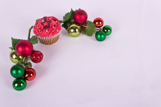 Christmas cupcake and tree ornaments on white background