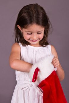 Little girl getting a gift from her Christmas stocking