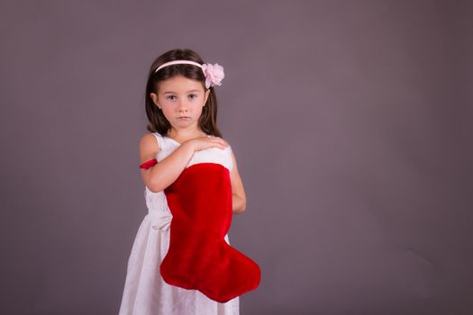 Sad little girl with Christmas stocking