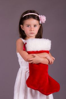 Sad little girl with Christmas stocking