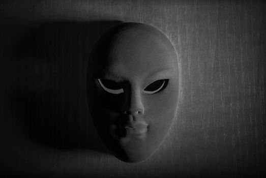 Carnival black and white mask in spooky shadow.