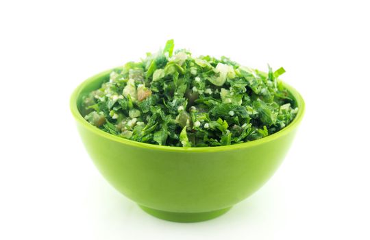 Tabbouleh salad in green plate on white .