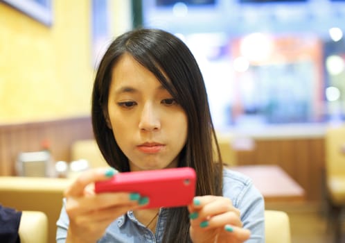 Asian woman using mobile phone take photo in restaurant