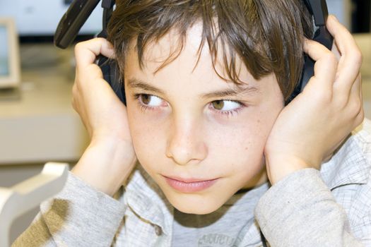 Portrait of a sweet young boy listening to music on headphones