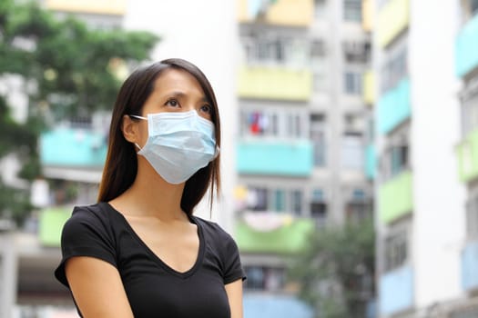 Woman wearing medical face mask in crowded city