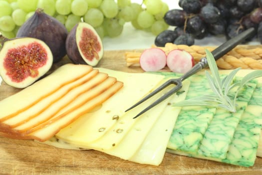 a wooden board with a variety of cheeses