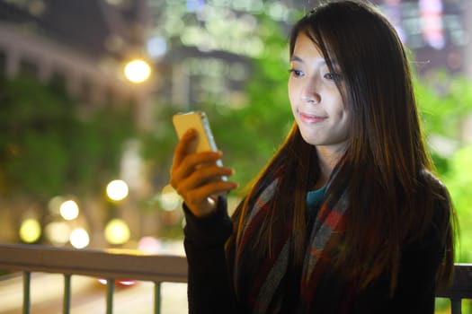 woman use mobile phone in city at night