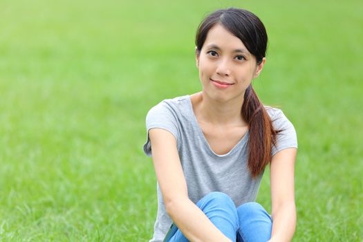 Asian woman setting on the grass